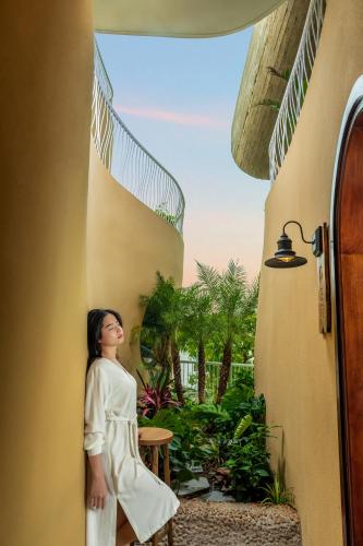 a woman in a white dress standing in a doorway at Saha Casa Boutique Hotel Da Nang in Da Nang