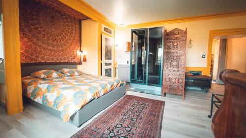 a bedroom with a bed and a rug at GITE COEUR DE NATURE in Abergement-le-Grand