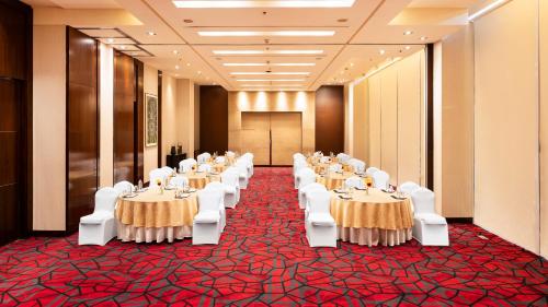 a banquet hall with tables and white chairs at Courtyard by Marriott Pune Hinjewadi in Pune