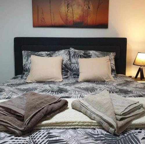 a bed with two pillows and towels on it at Apartman Djukic Sokobanja 1 in Soko Banja