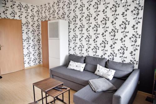 a living room with a couch and a wall with floral wallpaper at Haus JuliaN Wohnung 2 in Ueckermünde