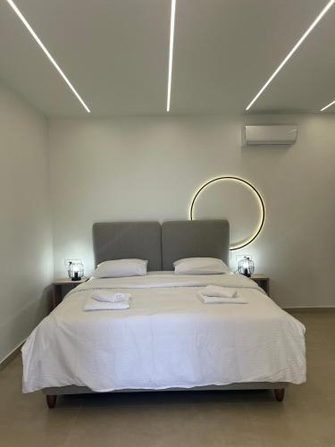 a bedroom with a large bed with a mirror on the wall at Lithitsa Lofts and Suites in Parga