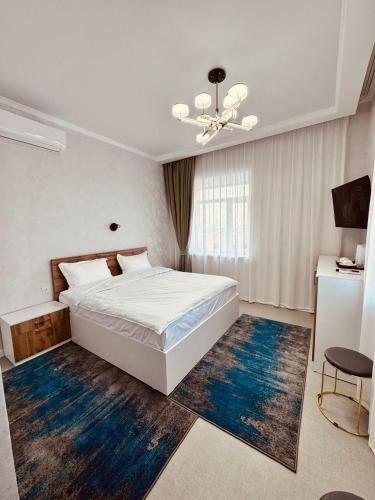 1 dormitorio con cama blanca y alfombra azul en Hotel Bereket Karaganda en Karagandá