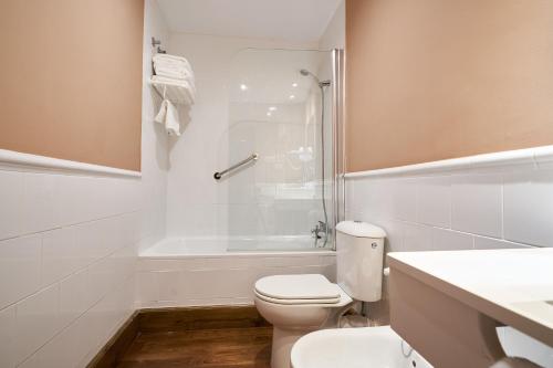 a white bathroom with a toilet and a shower at Quinta de Villanueva in Colombres