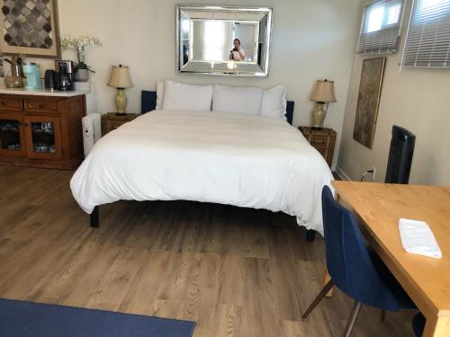 a bedroom with a large white bed and a wooden floor at Overlooking Marina del Rey sailboats, is Green Ginger Playa Del Rey on the bluff, in Los Angeles