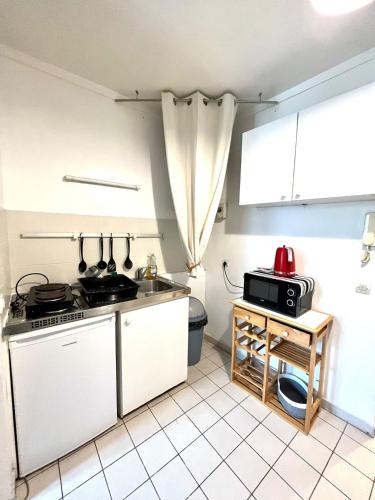 une cuisine avec un évier et une cuisinière four supérieur dans l'établissement COSY STUDIO in the center of Fontainebleau, à Fontainebleau