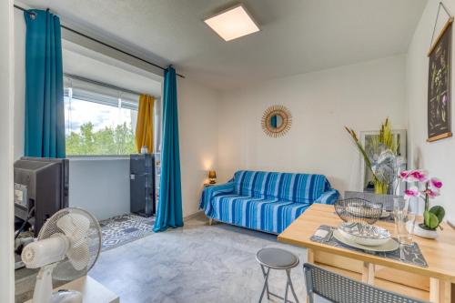 un salon avec un canapé bleu et une table dans l'établissement Le Cosy à la grande pyramide, à La Grande Motte