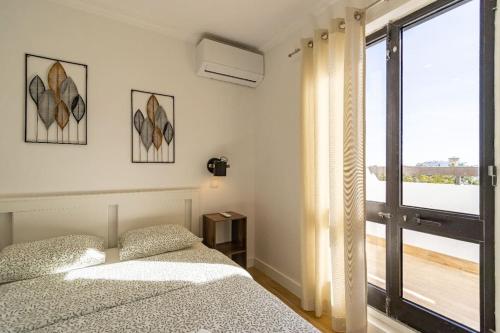 - une chambre avec 2 lits et une grande fenêtre dans l'établissement Cosy apartment in Albufeira, OURA ST, à Albufeira