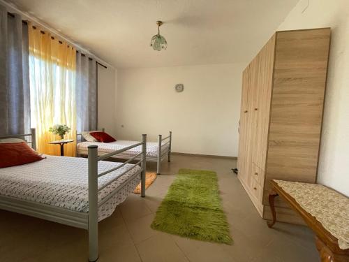 a bedroom with two beds and a green rug at Countriside Holiday Villa 