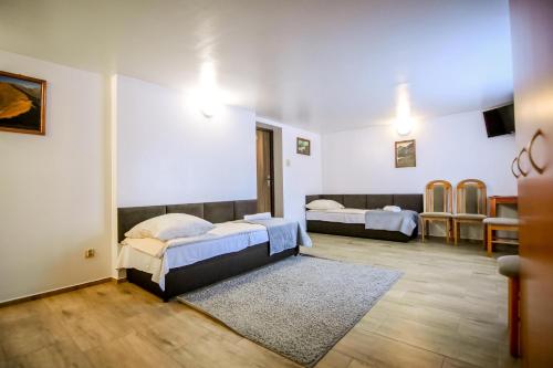a bedroom with two beds and a table and chairs at Willa Modra in Bukowina Tatrzańska