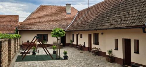 a house with a courtyard with a tree in it at Apartmány Pulgary in Bulhary