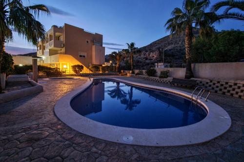 拉佐宜亞的住宿－Azohia Wellness，一座游泳池,位于一座拥有棕榈树的庭院内