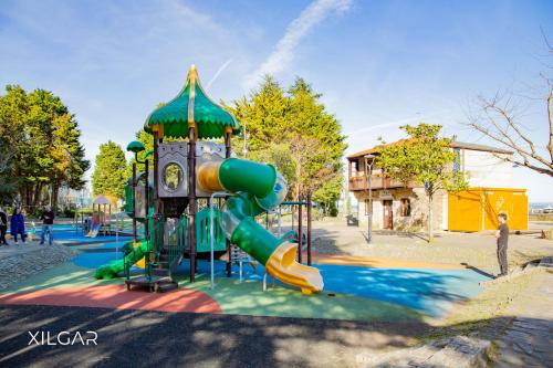 einen Spielplatz mit Rutsche in einem Park in der Unterkunft Casa VeiraMar in Pobra do Caramiñal