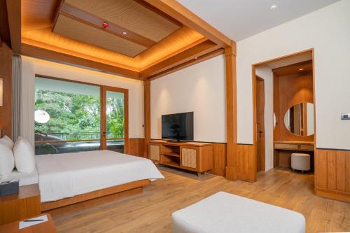 a bedroom with a bed and a television at Kristana Art and Culture Resort, ARTOTEL Curated in Ubud
