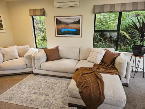 a living room with two couches and a couch at Tree Tops Retreat in Paihia