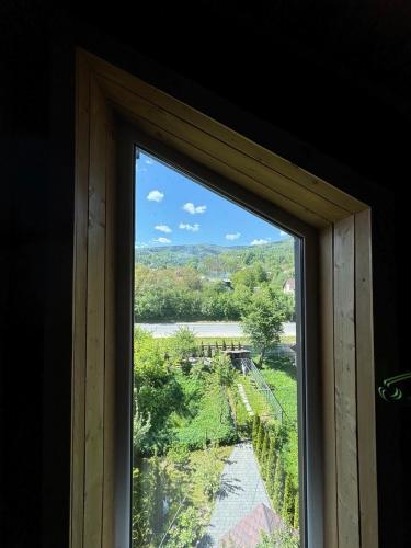 a window with a view of a river and trees at Girske Povitria 2 in Yaremche