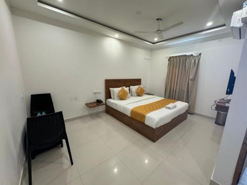 Hotel Airport City في بانغالور: غرفة نوم فيها سرير وكرسي