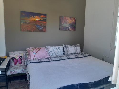 a bed in a bedroom with two pictures on the wall at For Your Vacations Only in Galatas