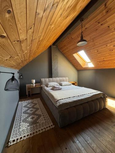 a bedroom with a large bed with a wooden ceiling at Girske Povitria 2 in Yaremche