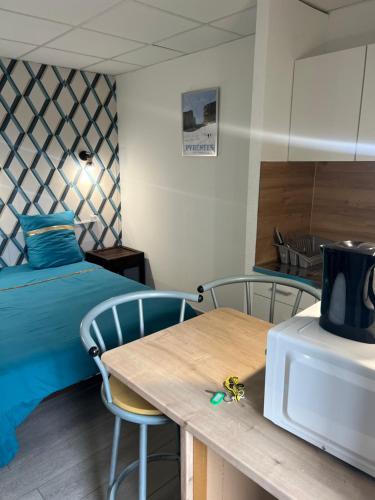 Zimmer mit einem Bett und einem Tisch mit einer Mikrowelle in der Unterkunft Résidence Sainte Thérèse - la villa Selva in Lourdes