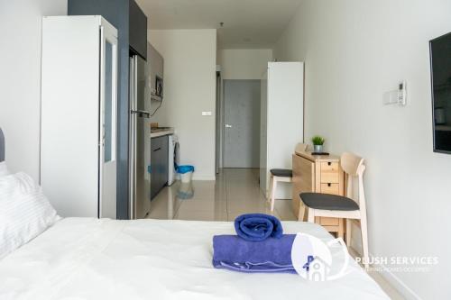 un letto bianco con un asciugamano blu sopra di Highpark Suites at Petaling Jaya a Petaling Jaya