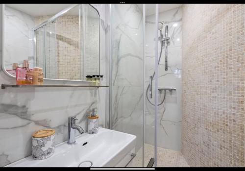 une salle de bain blanche avec une douche et un lavabo dans l'établissement Jolie studio cosy proche mer sur Juan les pins, à Antibes