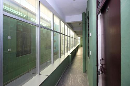 un pasillo de un hospital con paredes y ventanas verdes en OYO Hotel Global Inn, en Nueva Delhi