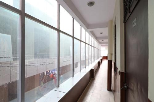 un pasillo vacío con grandes ventanas en un aeropuerto en OYO Hotel Global Inn, en Nueva Delhi