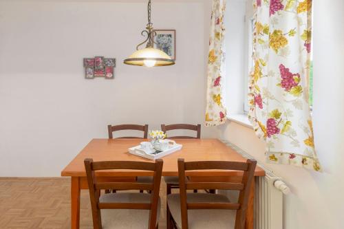 a dining room with a wooden table and chairs at Cozy Garden Flat in Ljubljana
