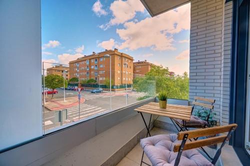 a balcony with a table and chairs and a large window at Zizur Confort by CLABAO in Zizur Mayor