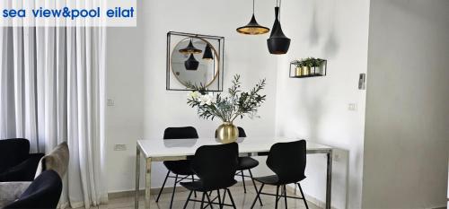 a dining room with a table with chairs and a mirror at sea view & pool eilat in Eilat