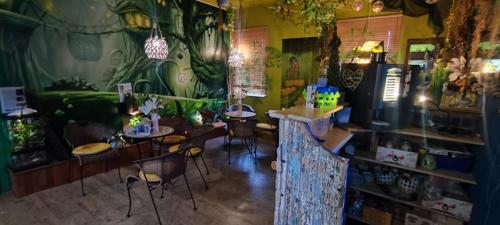 una habitación con mesas y sillas y una pared con plantas en Ferienhaus Eden Frankenblick, en Mengersgereuth-Hämmern