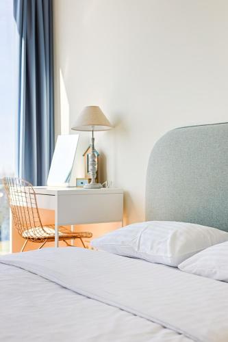 a bedroom with a bed and a desk with a laptop at Elija Swan-Toy Apartments in Šventoji