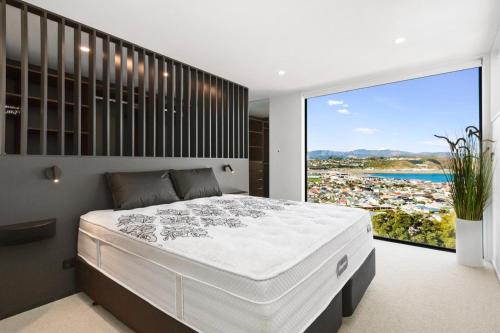 a bedroom with a large bed and a large window at Vista Mare in Wellington