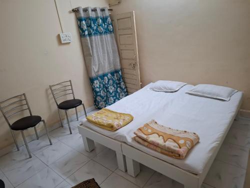 a room with a bed and two chairs in it at Chandrajyoti Villa 3 in Nagpur