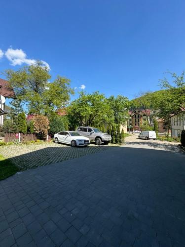 a driveway with two cars parked in a house at Girske Povitria 2 in Yaremche