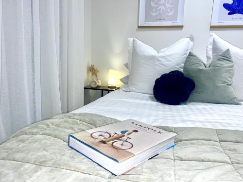 ein Buch auf einem Bett in der Unterkunft Wheturangi Urban Escape in Auckland