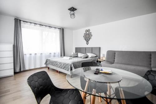 a bedroom with a bed and a table and chairs at Willa Modra in Bukowina Tatrzańska