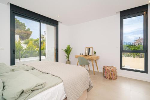 a white bedroom with a bed and large windows at Trito Spaniahome family friendly in Albir