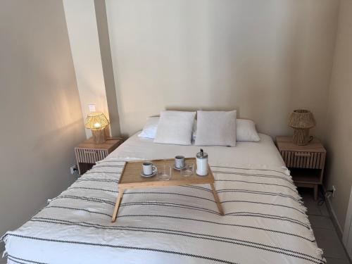 a bed with two mugs and a tray on it at Appartement Lemaitre in Marseille