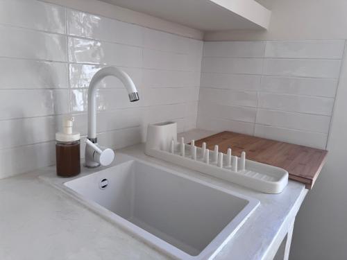 a white bathroom with a sink and a faucet at Appartement Lemaitre in Marseille