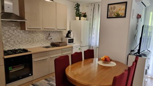 a kitchen with a wooden table and red chairs at Apartman Filipčić in Plitvička Jezera