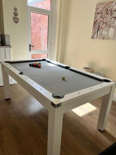 a pool table in a living room with at 4 bedroom, sleeps 8, 30 seconds from beach, games table in The Mumbles