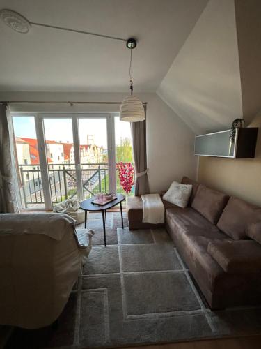 a living room with a couch and a table at Apartament Róża in Giżycko