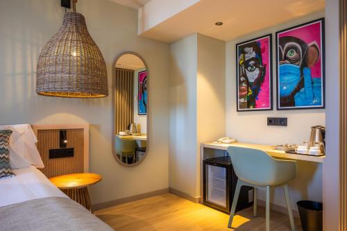 a bedroom with a bed and a desk and a table at Marins Beach Club - Adults Only Hotel in Cala Millor