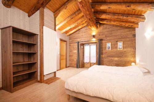 a bedroom with a bed and a wooden wall at Le Chalet du Villard in Saint-André