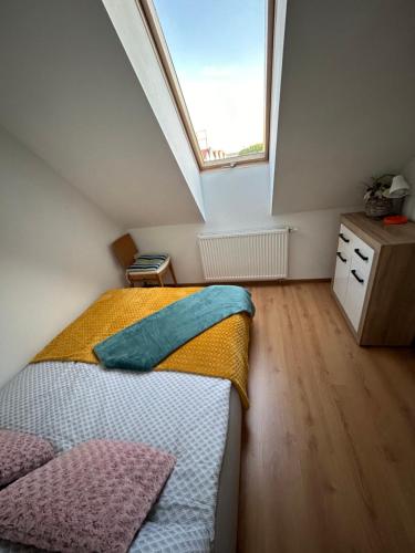 a attic bedroom with a bed and a window at Apartament Róża in Giżycko