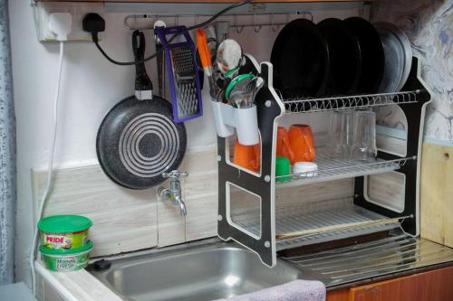 a kitchen sink with a drying rack above it at Little Lillies Homestays Nakuru in Nakuru