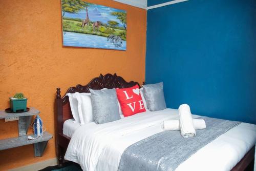 a bedroom with a bed with blue and orange walls at Little Lillies Homestays Nakuru in Nakuru