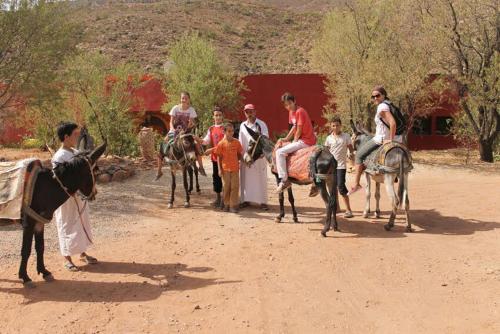 um grupo de pessoas andando a cavalo em uma estrada de terra em Ouadaker amizmiz em Amizmiz